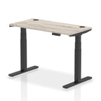 Adjustable height desk with wood-effect top and metal legs on a white background