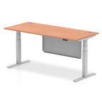 Adjustable height desk with wood-effect top and metal legs with modesty panel on a white background