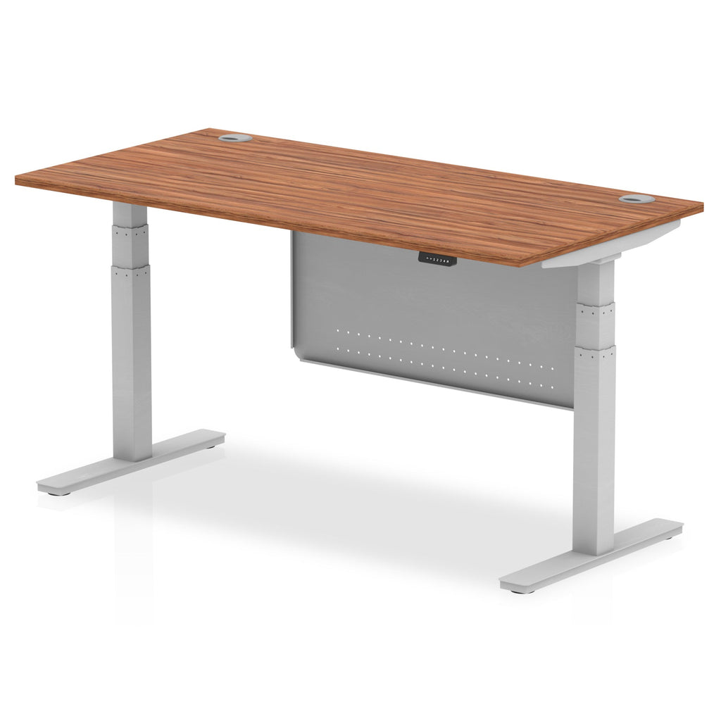 Adjustable height desk with wood-effect top and metal legs with modesty panel on a white background