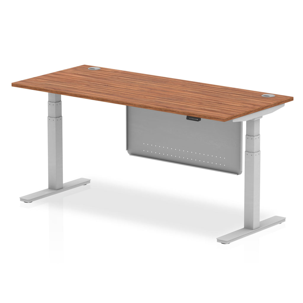 Adjustable height desk with wood-effect top and metal legs with modesty panel on a white background