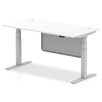 Adjustable height desk with white top and metal legs with modesty panel on a white background