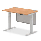 Adjustable height desk with wood-effect top and metal legs with modesty panel on a white background