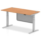 Adjustable height desk with wood-effect top and metal legs with modesty panel on a white background