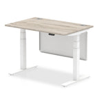 Adjustable height desk with wood-effect top and metal legs with modesty panel on a white background