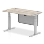 Adjustable height desk with wood-effect top and metal legs with modesty panel on a white background