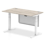 Adjustable height desk with wood-effect top and metal legs with modesty panel on a white background