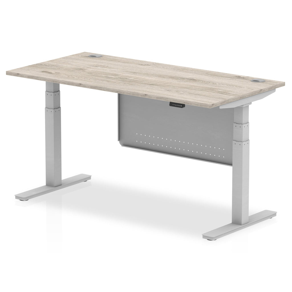 Adjustable height desk with wood-effect top and metal legs with modesty panel on a white background