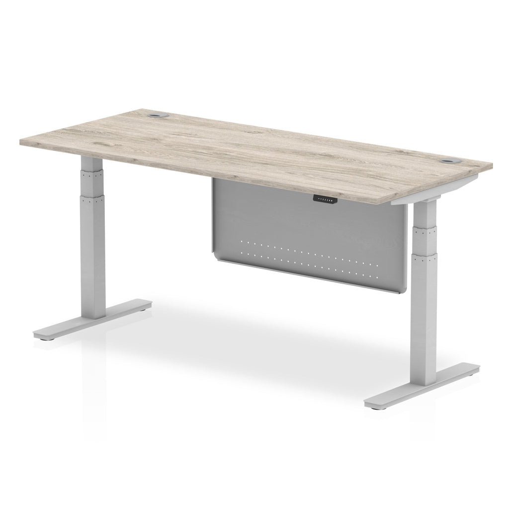 Adjustable height desk with wood-effect top and metal legs with modesty panel on a white background