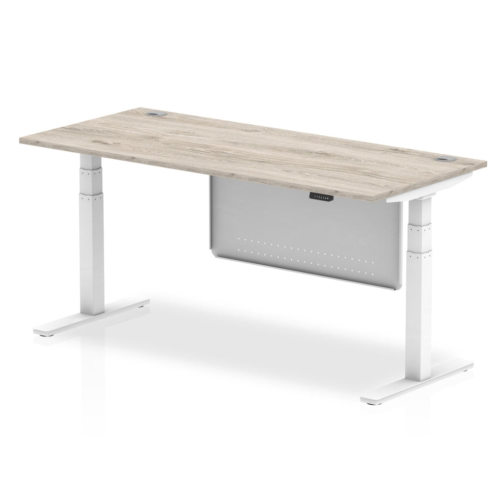 Adjustable height desk with wood-effect top and metal legs with modesty panel on a white background