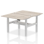 Back-to-back height adjustable desk with wood-effect top and metal frame on a white background