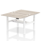 Back-to-back height adjustable desk with wood-effect top and metal frame on a white background