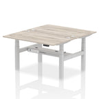 Back-to-back height adjustable desk with wood-effect top and metal frame on a white background