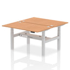 Back-to-back height adjustable desk with wood-effect top and metal frame on a white background