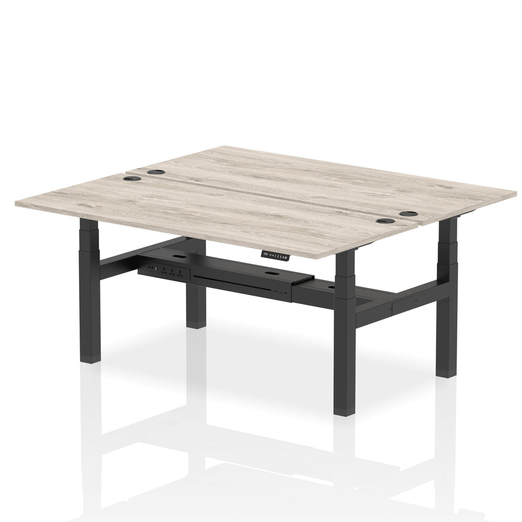Back-to-back height adjustable desk with wood-effect top and metal frame on a white background