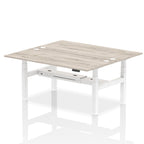Back-to-back height adjustable desk with wood-effect top and metal frame on a white background