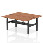 Back-to-back height adjustable desk with wood-effect top and metal frame on a white background
