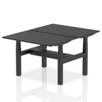 Back-to-back height adjustable desk with black top and metal frame on a white background