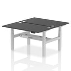 Back-to-back height adjustable desk with black top and metal frame on a white background