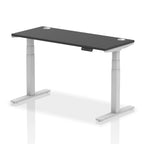 Adjustable height desk with black top and metal legs on a white background