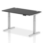 Adjustable height desk with black top and metal legs on a white background