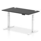 Adjustable height desk with black top and metal legs on a white background