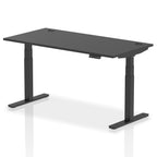 Adjustable height desk with black top and metal legs on a white background