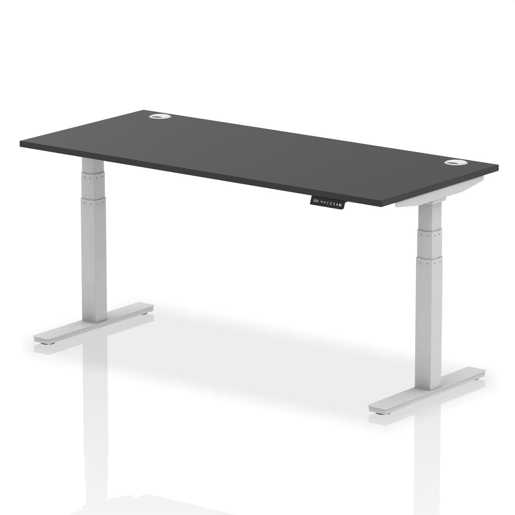 Adjustable height desk with black top and metal legs on a white background