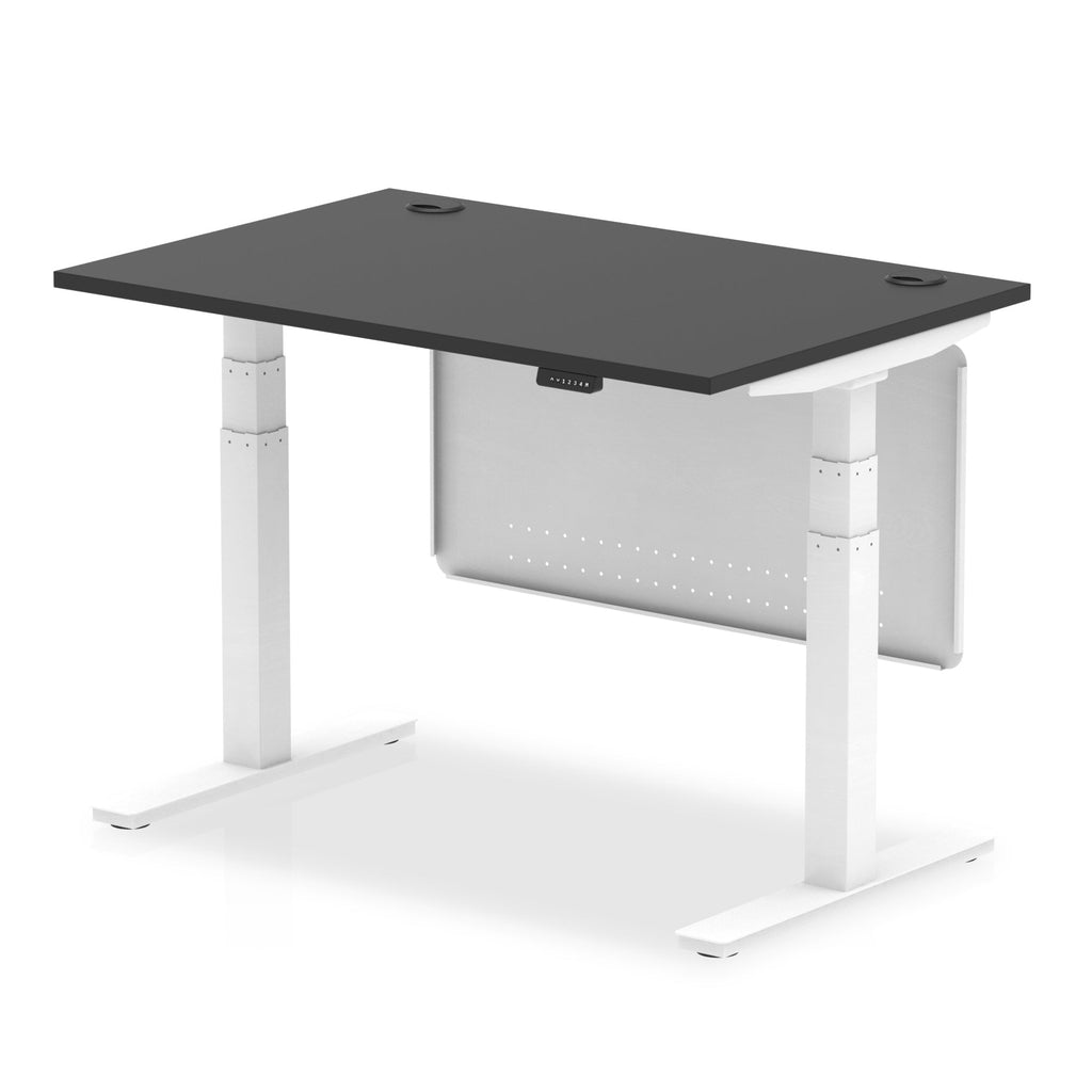 Adjustable height desk with black top and metal legs with modesty panel on a white background