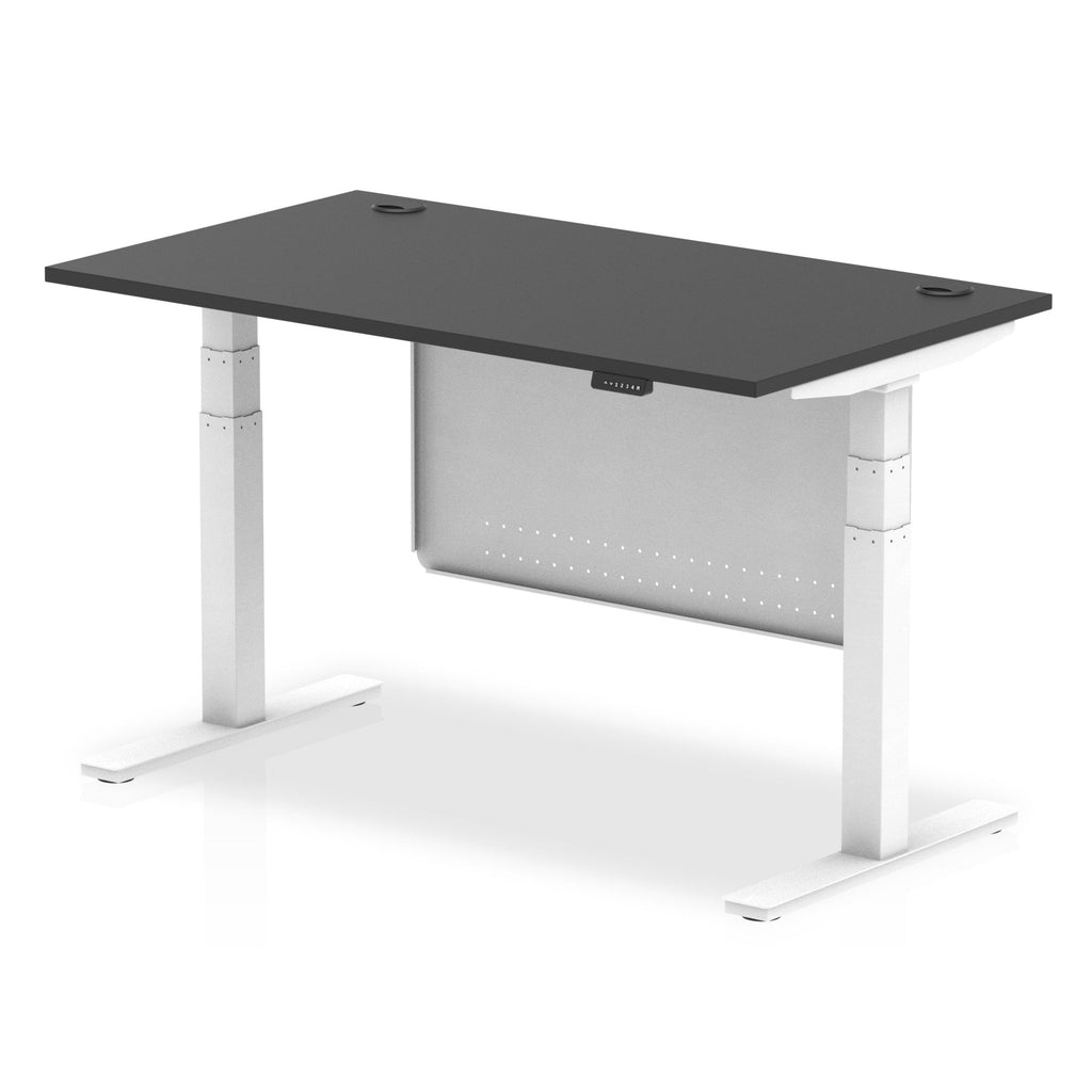 Adjustable height desk with black top and metal legs with modesty panel on a white background