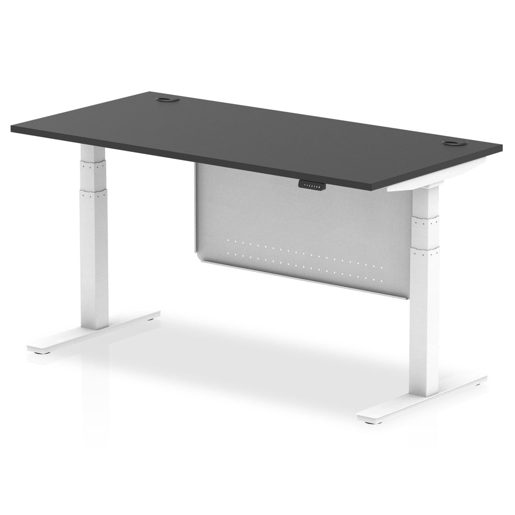 Adjustable height desk with black top and metal legs with modesty panel on a white background