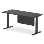 Adjustable height desk with black top and metal legs with modesty panel on a white background