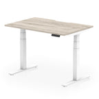 Height adjustable desk with wood-effect top and white frame on a white background