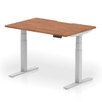 Height adjustable desk with wood-effect top and silver frame on a white background