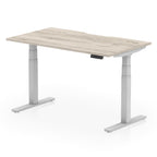 Height adjustable desk with wood-effect top and silver frame on a white background