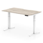 Height adjustable desk with wood-effect top and white frame on a white background