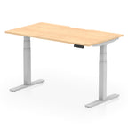 Height adjustable desk with wood-effect top and silver frame on a white background