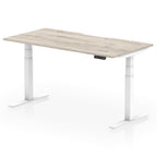Height adjustable desk with wood-effect top and white frame on a white background