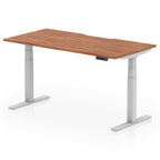 Height adjustable desk with wood-effect top and silver frame on a white background