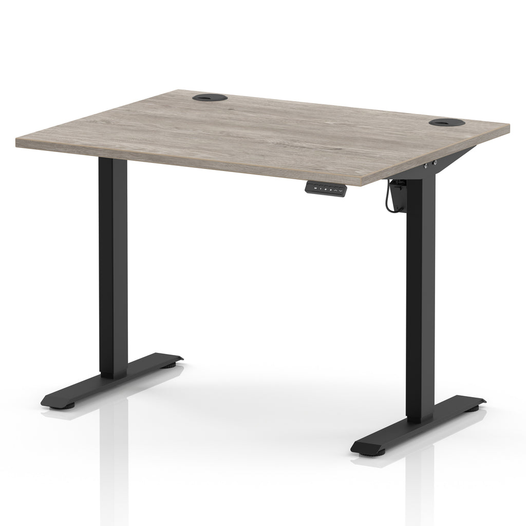 An adjustable standing desk with a light grey wood-grain desktop and black metal legs, shown on a clean white background.