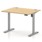 An adjustable height standing desk with a light natural wood grain top and a silver metal frame, shown on a white background.