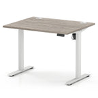 An adjustable height standing desk with a light grey wood-grain desktop and white metal legs, shown on a clean white background.