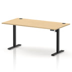 An adjustable height standing desk with a light wood grain top and black metal legs, shown on a clean white background.