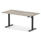Height adjustable desk with grey wood-effect top and black frame on a white background