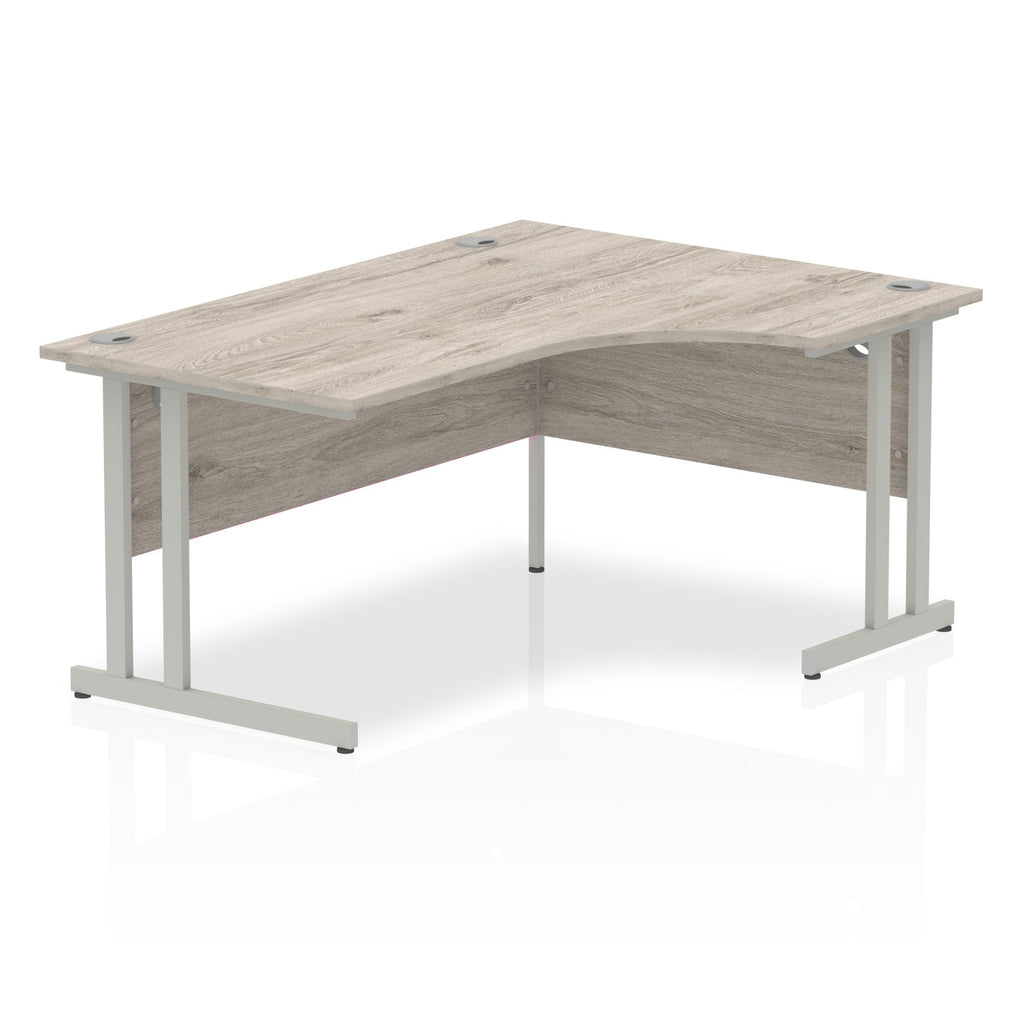 Grey wood-effect L-shaped desk with metal legs on a white background