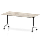 Rectangular table with a grey wood-effect flip top and black and chrome metal legs on wheels against a white background