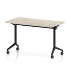 Rectangular table with a grey wood-effect top and black metal legs on wheels against a white background