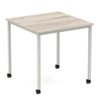 Square table with a wood-effect top and metal legs with castors on a white background