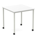 Square table with a white top and metal legs with castors on a white background
