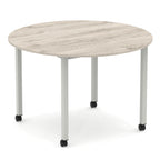Round table with wood-effect top and metal legs with castors on a white background