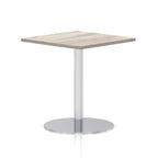Square table with a grey wood-effect top and silver cylindrical base on a white background